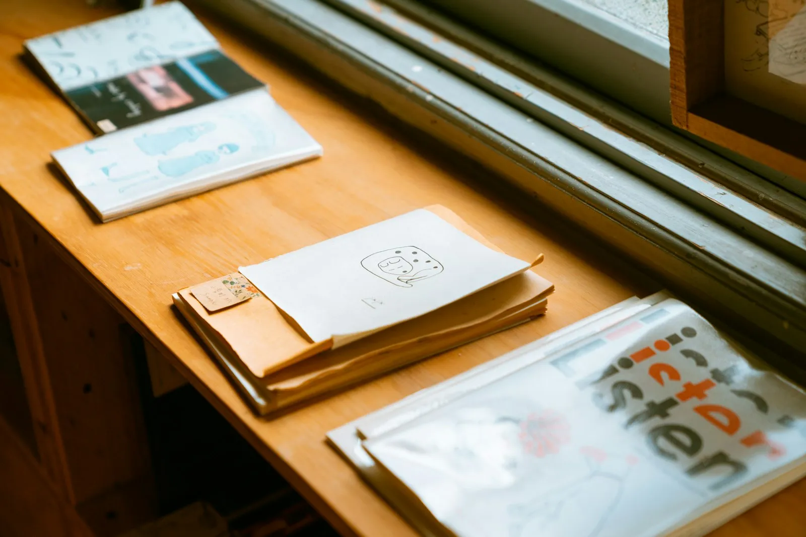 窓辺の木の机に置かれた冊子と書類